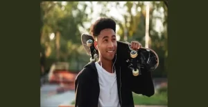 A boy caring a skateboard